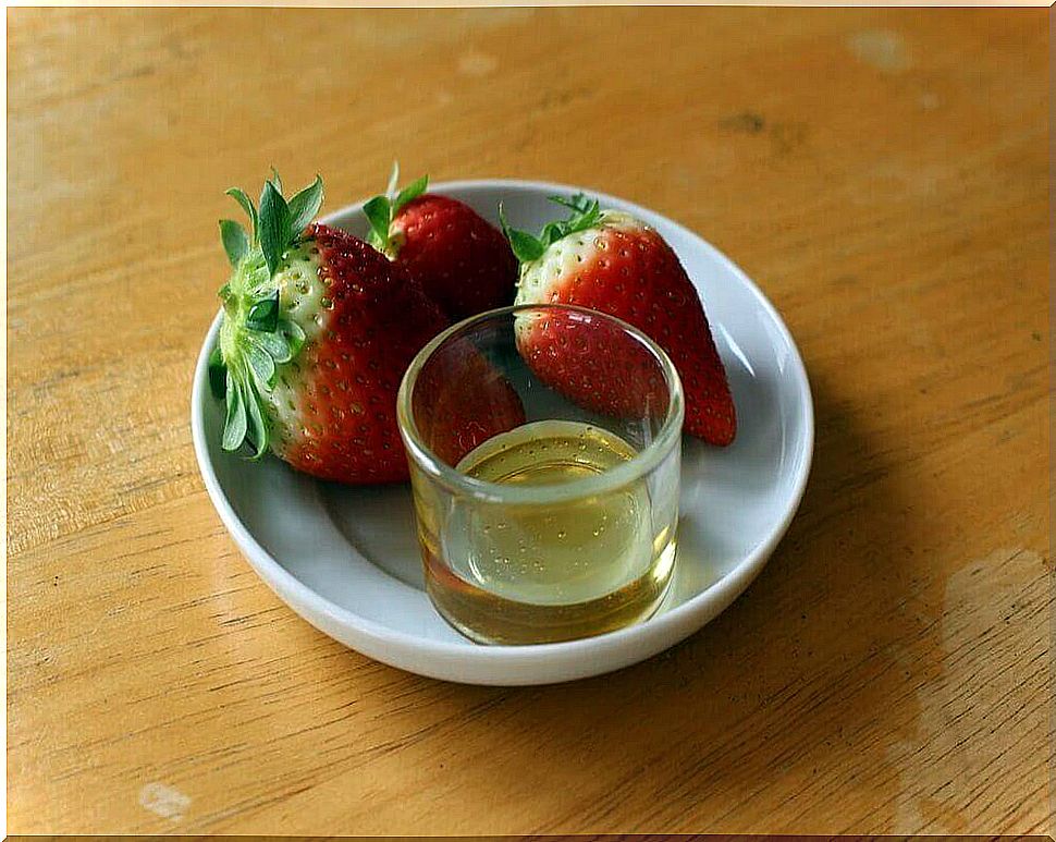 Strawberries on a plate with a glass of olive oil