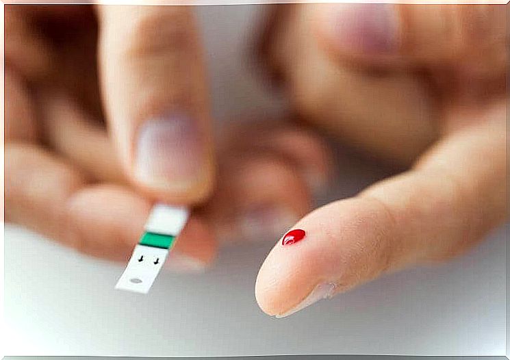 Finger with a drop of blood and a test swab