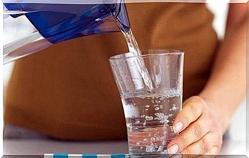 Woman pours a glass of water