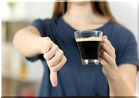 Woman holds thumb down over coffee