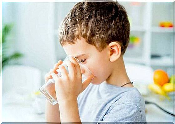 Boy drinks a glass of water